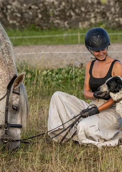 Frau mit Pferd und Hund auf der Wiese